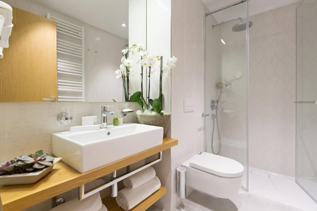 A well-lit bathroom, showing a sink, toilet, and shower
